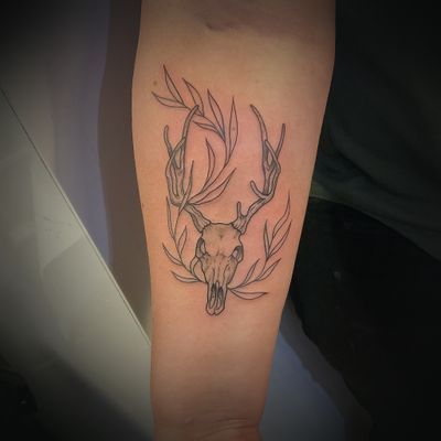 Deer skull tattoo with plant 
