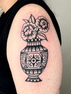 Capture the beauty of nature with Clara Colibri's illustrative and traditional flower vase tattoo. A timeless piece of art for your skin.