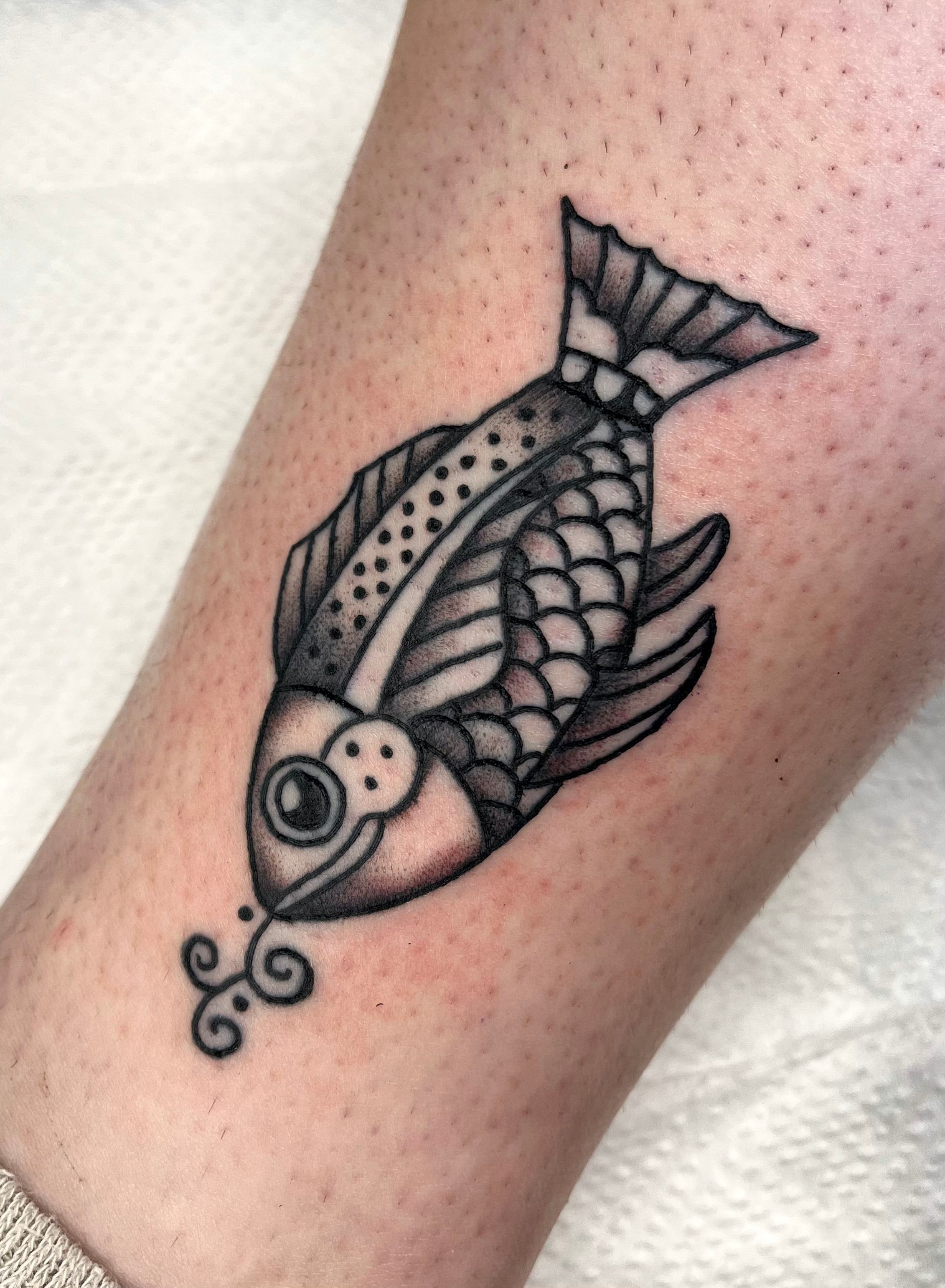 Koi fish tattoo located on the inner forearm, done in