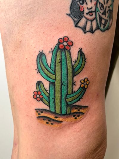 Get a timeless and vibrant cactus tattoo in traditional style by the talented artist Clara Colibri. Perfect for those who appreciate desert motifs and classic tattoo art.