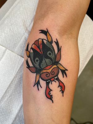Get a stunning traditional tattoo of a stag beetle done by Clara Colibri, known for her detailed illustrative style.