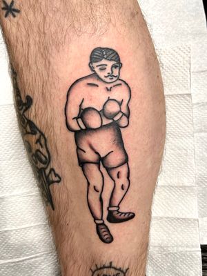 Get inked with a traditional style boxer tattoo by Clara Colibri, showcasing strength and determination.
