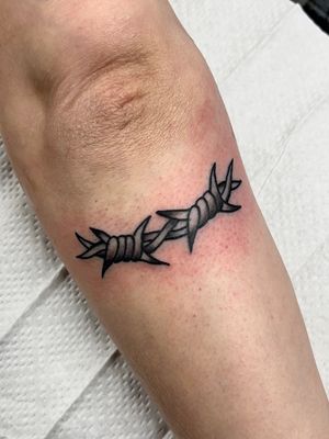 Get a bold and edgy look with this illustrative barbed wire tattoo by Clara Colibri. Perfect for those who love unique and intricate designs.
