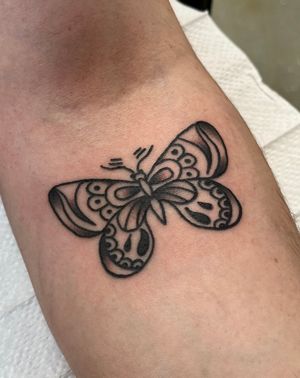 A stunning traditional style butterfly tattoo by Clara Colibri, featuring intricate details and vibrant colors.