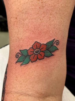 Capture the timeless beauty of a traditional flower tattoo designed by Clara Colibri. Embrace the elegance and vibrant colors of this stunning piece.