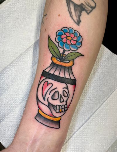 Get inked with a stunning traditional tattoo featuring a beautiful flower and a fierce skull designed by Clara Colibri.