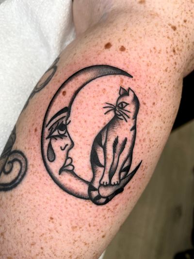 Get a mystical vibe with this traditional style tattoo featuring a moon and cat motif by Clara Colibri.