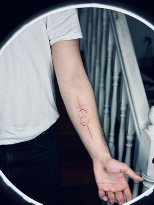 Elegant and minimalist tattoo featuring a moon and star design, expertly executed with fine lines and geometric shapes by artist Tal.