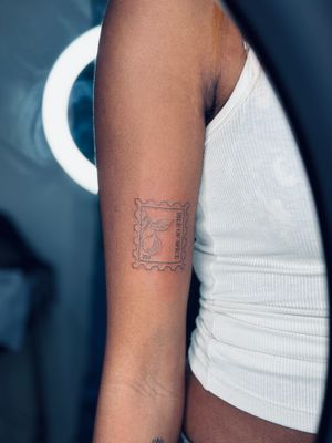 Elegant and intricate tattoo featuring a stamp design on dark skin, created by the talented artist Tal.