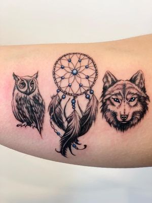 Experience the magic of black & gray illustration by Epic Tattoos Guildford with this stunning tattoo featuring a wolf, owl, and dreamcatcher design.