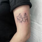 Illustrative tattoo by Emily Bonnet capturing friends enjoying tea at a table in delicate fine line style.