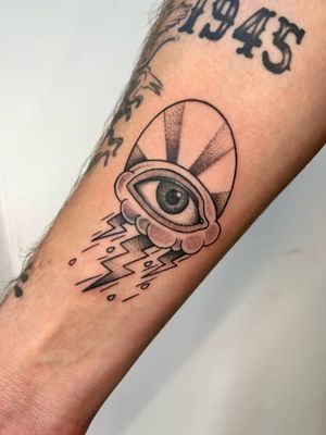 Illustrative tattoo by Ben Prescott featuring a somber eye amidst a powerful storm motif.