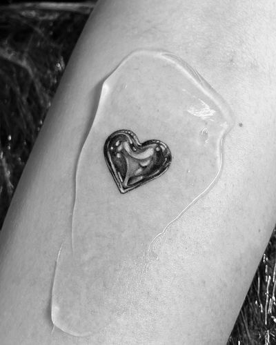 Experience the beauty of a black and gray illustrative tattoo featuring a chrome metallic heart design by the talented artist Vera.
