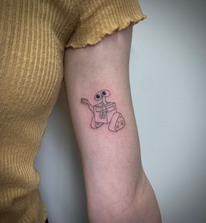 Capture the magic of Disney with this delicate fine line tattoo by Chloe Hartland, featuring everyone's favorite robot WALL-E.