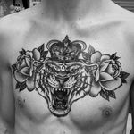Striking black and gray tattoo by Laurel combining a fierce tiger with a delicate rose in a chicano illustrative style.