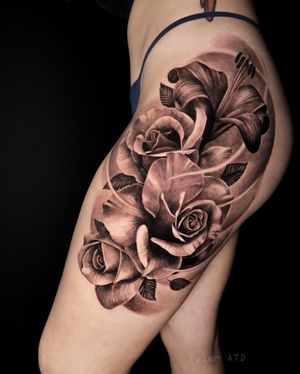 Hip to thigh floral tattoo. Roses and lilys in black and grey realism.