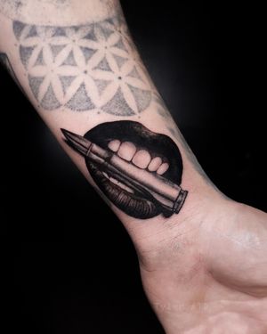 Bite the bullet micro realistic black and grey tattoo.