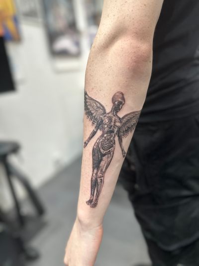 Embrace the essence of Nirvana's iconic album with a realistic black and gray tattoo by Saka Tattoo. Let the music live on your skin forever.