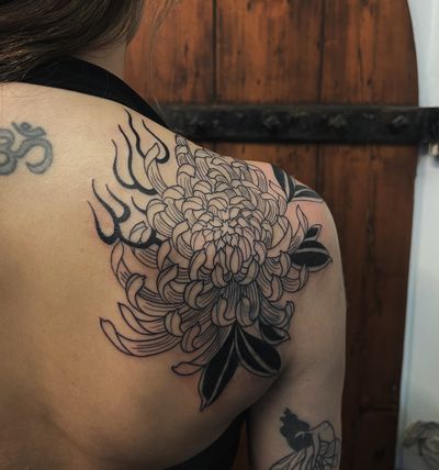 Experience a stunning fusion of floral beauty and fiery energy in this unique tattoo by artist Claudia Vicente.