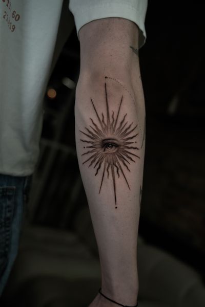 Delphin Musquet's black and gray tattoo features a stunning micro realism design of a star and eye. A unique and intricate piece of art.
