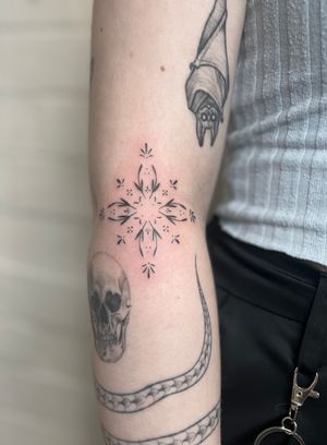 Discover the beauty of hand-poked ornamental design with this delicate and intricate tattoo by artist Marketa. Perfect for those who appreciate fine details.