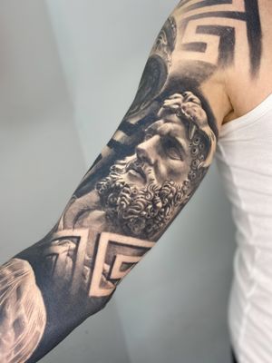 Experience the strength and power of Hercules in this realistic black and gray tattoo by Gaston Gromnicki.