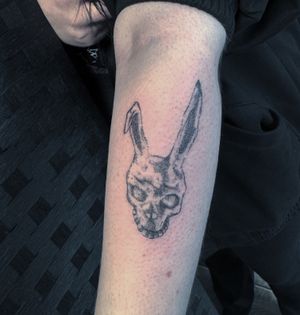 Get mesmerized by Kiky Flore's intricate dotwork hand poke tattoo inspired by the iconic Donnie Darko motif. Dive into the surreal world of this cult classic with this unique and stunning design.