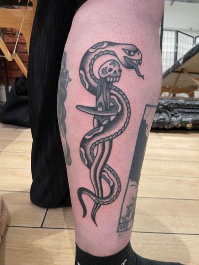 Get inked with a classic traditional tattoo featuring a snake and dagger design by Goblyn Crew. Perfect for bold and timeless body art.