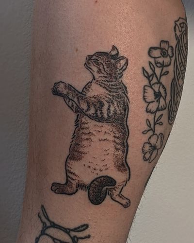 Get a unique blackwork and illustrative hand-poked cat tattoo by the talented artists at Alien Ink.
