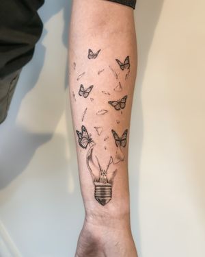 Black and grey realism light bulb bursting open with butterflies 