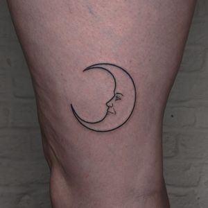 Capture the beauty of the moon with this delicate fine line tattoo by talented artists at Alien Ink. Perfect for those who love celestial motifs.