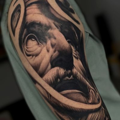 Experience the stunning detail of a black and gray statue tattoo by the talented artist Gaston Gromnicki.