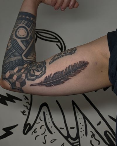 Experience the intricate beauty of hand-poked dotwork with this unique feather tattoo design by Alien Ink.