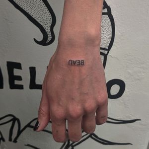 Get a stylish small lettering tattoo by the talented artists at Alien Ink. Perfect for those looking for a subtle yet meaningful design.