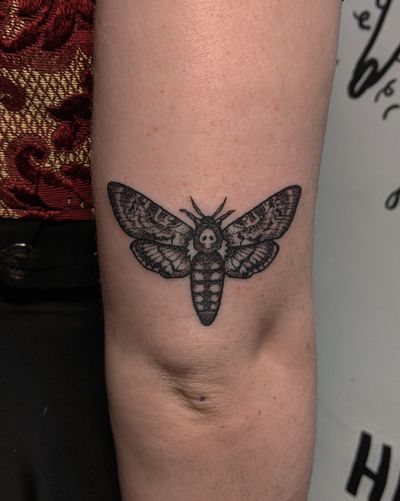 Embrace the haunting beauty of a hand-poked blackwork moth tattoo by the talented artist at Alien Ink.