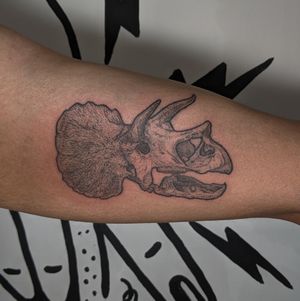 Get a bold blackwork tattoo featuring a unique combination of skull and triceratops motifs by Alien Ink.