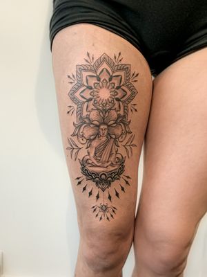 Black and grey buddha meditating on a lotus with mandala patterns in the background.