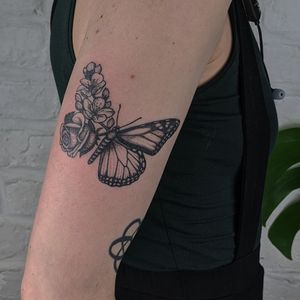 Beautiful handmade dotwork tattoo featuring a butterfly and flower design by Alien Ink.
