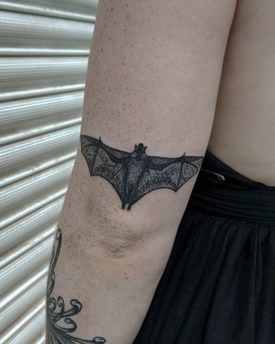 Embrace the darkness with a unique hand-poked bat tattoo by Alien Ink. Intricate dotwork details create a stunning, one-of-a-kind design.