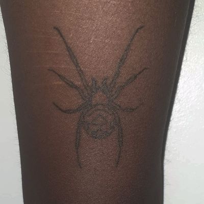 Get a unique hand-poked spider tattoo on dark skin by the talented artists at Alien Ink. Embrace the dark side with this intricate design.