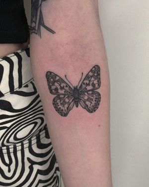 Embrace the beauty of nature with this intricate dotwork butterfly design by Alien Ink. Hand-poked for a unique and artistic touch.