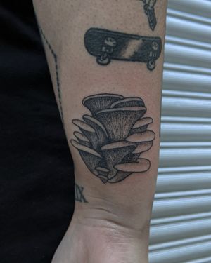 Experience the enchanting beauty of dotwork and hand-poke styles combined in this unique illustrative mushroom tattoo by the talented artists at Alien Ink.