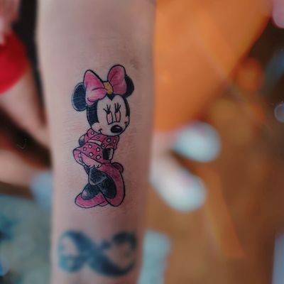 Get a whimsical and charming illustrative Disney tattoo featuring the iconic character Minnie Mouse, expertly done by Larisa Andreea Boboc.