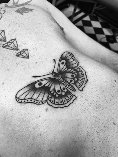 Experience the timeless beauty of a traditional butterfly tattoo designed by Laurel, featuring vibrant colors and intricate details.