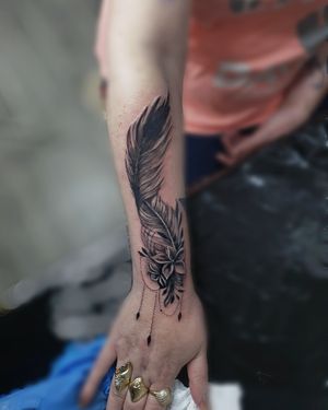 Get a stunning feather tattoo with intricate ornamental details done by the talented artist Larisa Andreea Boboc.