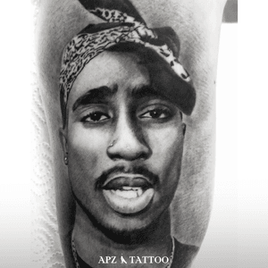 Tupac Shakur Portrait Tattoo in Black & White Realism on Bicep by Apz in Copenhagen, Denmark. In Copenhagen, APZ, a world-class tattoo artist, crafts modern black and gray realism portraits. His Tupac Shakur piece on a bicep speaks volumes with its lifelike realism. APZ’s talent travels from Copenhagen to New York to Dubai, leaving impactful, soulful marks wherever he goes. Want to get a unique reminder? APZ is here to help you. Explore his portfolio on Instagram: @apztattoo. #surrealism #realism #black&gray #tattoodoambassador #blackandgray #realism #surrealism #microrealism 
