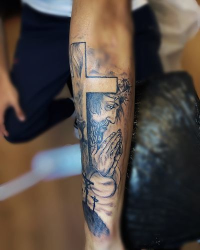A religious tattoo featuring a cross and Jesus, beautifully illustrated by Larisa Andreea Boboc.