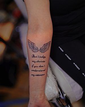 Elegantly crafted small lettering with illustrative wings by tattoo artist Larisa Andreea Boboc. Embrace your inner freedom and soar.