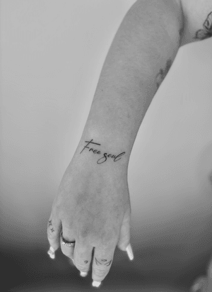 Get a dainty and elegant small lettering tattoo by artist Ruth Hall for a minimalistic yet meaningful touch.