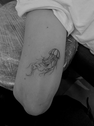 Discover the beauty of a fine line jellyfish tattoo by renowned artist Ruth Hall. Dive into the depths of creativity with this mesmerizing design.